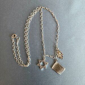 Handmade charm silver color metal necklace with Star of David and Hamsa hand.